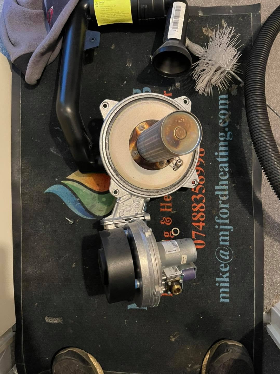 Burner and fan assembly laid on the M.J.Ford Heating work mat